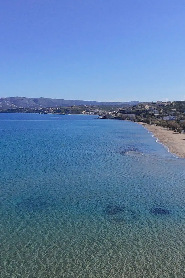 White sandy beach and calm turquoise waters at Kiani Akti Beach, a relaxing spot in Crete.